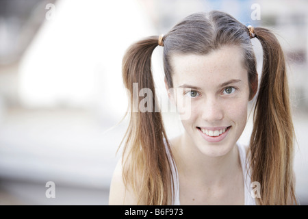 Ragazza di 17 anni con i suoi capelli in ponytails, sorridente Foto Stock