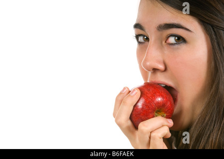 Chiudere orizzontale su ritratto di un giovane attraente ragazza adolescente di mangiare una succosa red Braeburn apple contro uno sfondo bianco Foto Stock