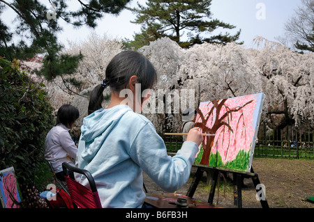 Ragazza pittura fiori di ciliegio durante il Cherry Blossom festival in una pittura amatoriale gruppo nel Palazzo Imperiale parco in K Foto Stock