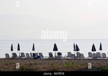 Sedie a sdraio e ombrelloni sulla spiaggia Foto Stock