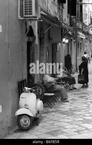 Alley con anziani e uno scooter a Kerkyra, città di Corfù, Grecia, Europa Foto Stock