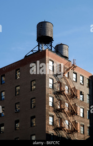 Un edificio a più piani con legno di due serbatoi di acqua sul tetto, New York City, Stati Uniti d'America Foto Stock