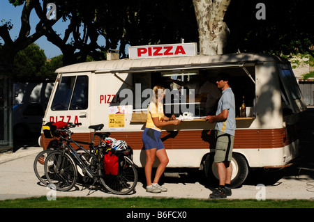 I ciclisti nella parte anteriore della pizza-stand in Tarascon, Provence, Francia Foto Stock