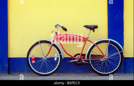 Red cruiser bicyle contro il blu e il giallo della parete città Dewey Culebra Island Puerto Rico Foto Stock