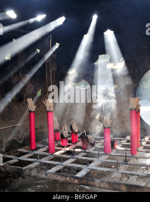 Alberi di luce del sole che mostra nell'incenso del fumo da offerte a un tempio buddista 2/2 Foto Stock