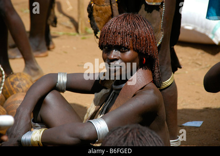 Una donna dalla Hamar tribù con argilla rossa come Capelli decorazione seduta sul terreno, mercato di Dimeka, Etiopia, Africa Foto Stock