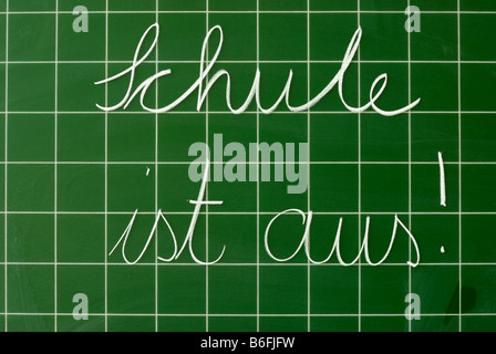 Testo scritto a mano in tedesco su una lavagna con griglia, Schule ist aus!, School's out! Foto Stock