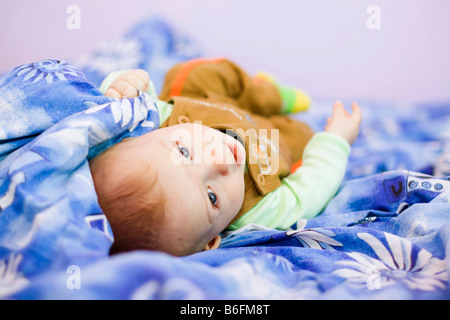 Baby boy, 7 mesi, sul letto Foto Stock