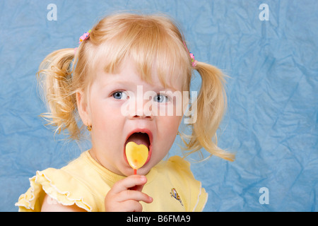 La bionda bambina di 2 anni, con lecca-lecca Foto Stock