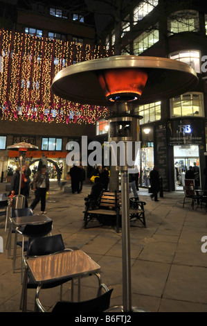 London West End a tempo di Natale ristoranti che forniscono all'aperto riscaldatore a gas accanto a tavole per mangiare fuori simile al cosiddetto giardino patio riscaldatori REGNO UNITO Foto Stock