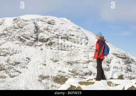 Una donna che cammina sulla Caudale Moor guardando verso il rosso ghiaioni sopra Ambleside nel distretto del lago REGNO UNITO Foto Stock