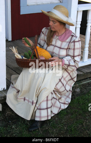 Una signora che va oltre la sua verdura che ha prelevato seduti sulla veranda della casa Foto Stock
