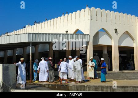 Omani uomini che indossano il costume nazionale in chat di fronte la Mutrah mercato del pesce, Moscato, il sultanato di Oman Foto Stock