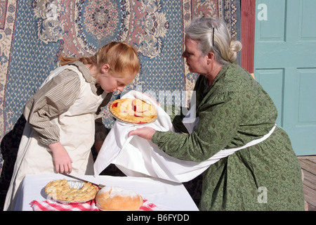 Una giovane ragazza annusando come buona la torta di ciliegie odori che lei e sua nonna realizzato Foto Stock