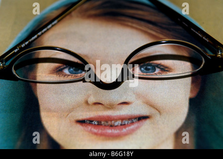 Glasse di lettura seduto su una foto in un giornale, Bawdsey, Suffolk, Regno Unito. Foto Stock