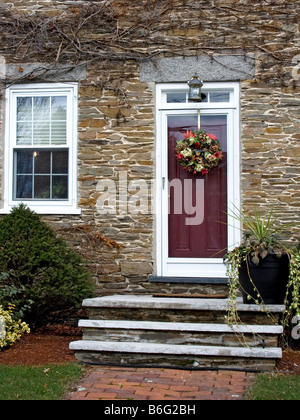 Una ghirlanda di Natale appeso sulla porta di una casa di pietra in West Newbury Massachusetts Foto Stock