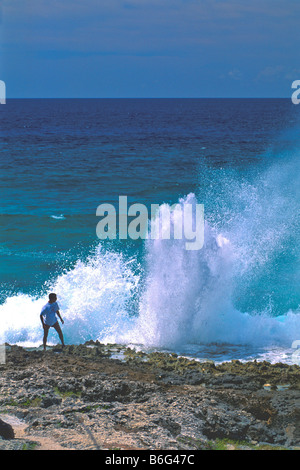 Foro di sfiato Grand Cayman Island uomo essendo coperta in spray come blowhole esplode geyser simili Foto Stock