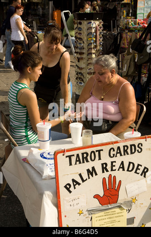 Tarocchi e Palm Reader legge una giovane donna s Palm a una fiera di strada in Sunset Park Brooklyn NY Foto Stock