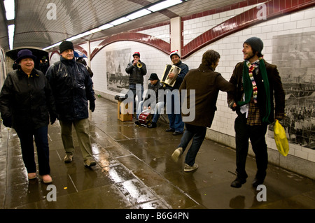 La gente ballare davanti a un gruppo di artisti di strada in un sottopassaggio sulla South Bank di Londra. Foto Stock