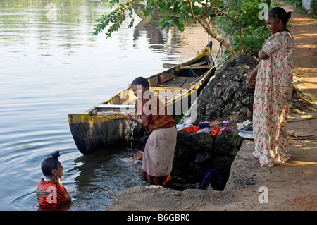 Il lavaggio delle donne sulle rive del Canal nelle lagune del Kerala India Foto Stock