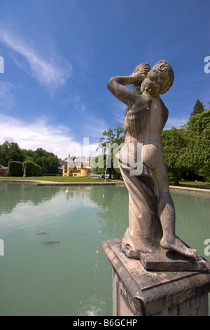 Vista posteriore di una fontana di acqua con il Castello di Hellbrunn in background nella periferia di Salisburgo Foto Stock