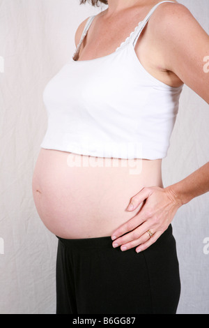 Primo piano della gravidanza stomaco womans bump a 28 settimane 7 mesi di gestazione sette di una serie di dieci time lapse immagini di gravidanza Foto Stock