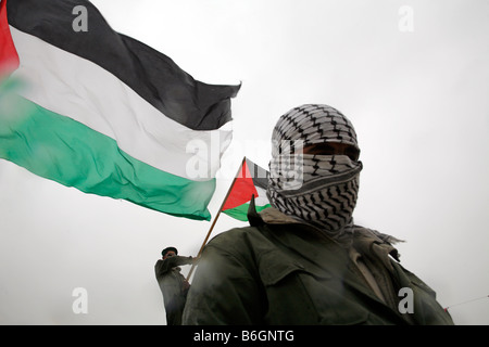 Un manifestante palestinese in posa di fronte di bandiere palestinesi nel villaggio di Bilin, vicino a Ramallah in Cisgiordania. Foto Stock