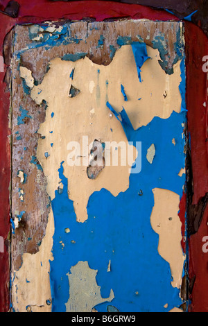 Rosso e blu vernice peeling su una porta di legno Foto Stock