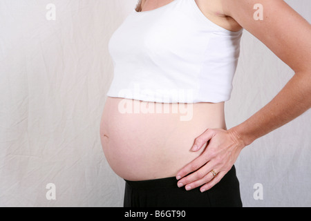 Primo piano della gravidanza stomaco womans bump a 28 settimane 7 mesi di gestazione sette di una serie di dieci time lapse immagini di gravidanza Foto Stock