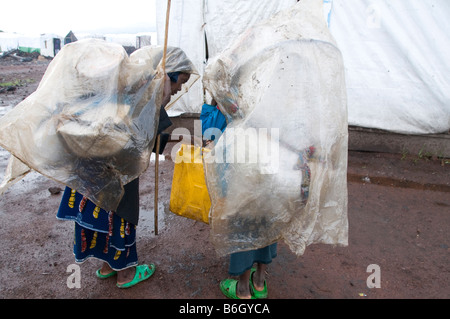 Goma giovedì 21 novembre 2008 Kibati camp due donne ricoperti di plastica arriva sotto la pioggia che trasportano le loro merci worldy Foto Stock