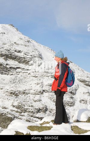 Una donna che cammina sulla Caudale Moor guardando verso il rosso ghiaioni sopra Ambleside nel distretto del lago REGNO UNITO Foto Stock