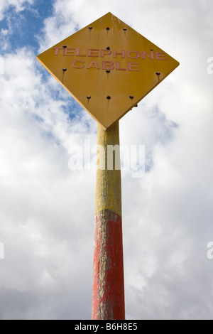 Segno di avvertimento del cavo telefonico al di sotto sulla spiaggia di Aldeburgh Foto Stock