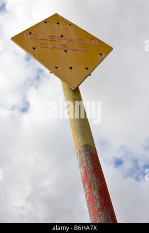 Segno di avvertimento del cavo telefonico al di sotto sulla spiaggia di Aldeburgh Foto Stock