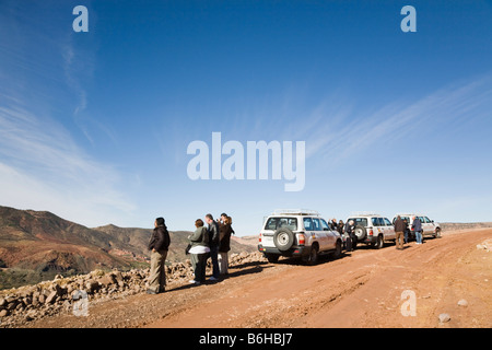 Valle di Asni Marocco dicembre turisti e 4x4 offroad safari accanto a veicoli su strada sterrata in colline ai piedi dell'Alto Atlante Foto Stock