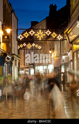 Le figure sfocate di acquirenti di Natale su Fore Street nella città Tynedale di Hexham, Northumberland, Inghilterra Foto Stock