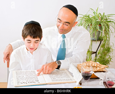 Padre e figlio celebrando la Pasqua la lettura della Hagada Foto Stock