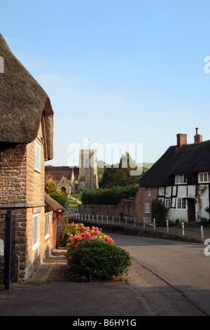 Il villaggio principale strada che conduce alla chiesa parrocchiale di st Andrews in Okeford Fitzpaine, a nord del villaggio di Dorset Foto Stock