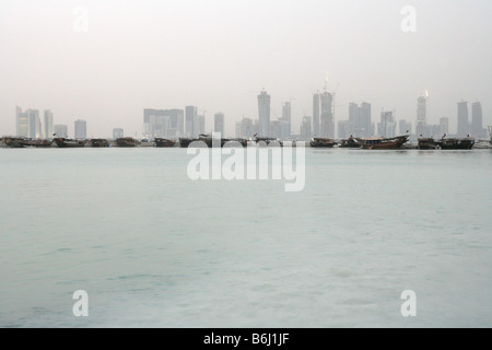 Vista in lontananza di Doha skyline e la fila di barche dalla baia, Qatar, Medio Oriente Foto Stock