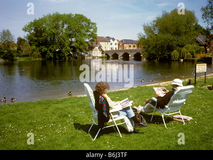 Regno Unito Inghilterra Hampshire Fordingbridge giovane rilassante in sedie pieghevoli sulle rive del fiume Avon Foto Stock