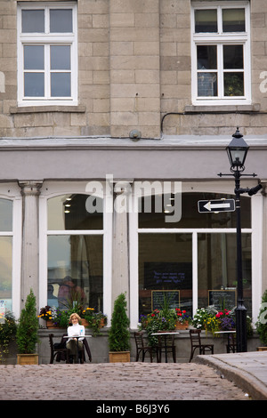 Donna seduta al tavolo sul marciapiede esterno delicatessen su Rue Saint Paul nella Città Vecchia Quebec Montreal Canada Foto Stock