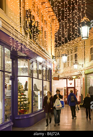 Gli amanti dello shopping a piedi attraverso Victorian shopping arcade a Natale Cardiff Wales UK Foto Stock