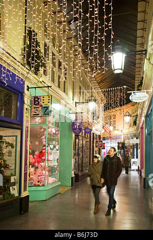 Gli amanti dello shopping a piedi attraverso Victorian shopping arcade a Natale Cardiff Wales UK Foto Stock