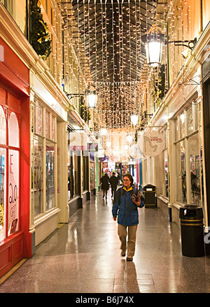 Gli amanti dello shopping a piedi attraverso Victorian shopping arcade a Natale Cardiff Wales UK Foto Stock