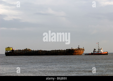 Barge in traino da un rimorchiatore nel Mare del Nord fuori dalla costa di Suffolk, Regno Unito. Foto Stock