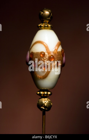 Dettaglio di un Victorian/Edwardian ladies hat pin adornata con una fantasia di vetro veneziano tallone e varie altre piccole perle d'oro. Foto Stock