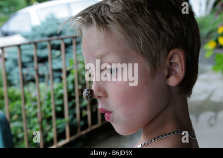 Un ragazzo con una lumaca sul suo naso, la natura della versione di un clown naso Foto Stock