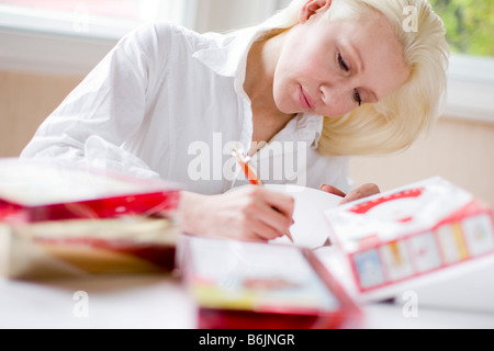 La donna a scrivere cartoline di Natale Foto Stock