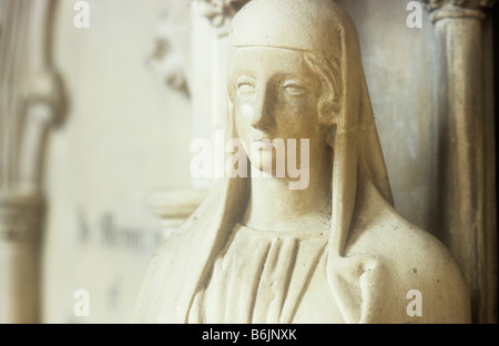 Dettaglio della tomba scolpita statua medioevale dei womans di testa e spalle con wimple e abito in una luce calda Foto Stock