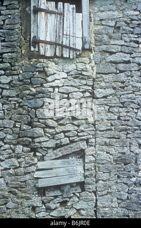 Dettaglio di due piani parete stalattite granaio è stato esteso ma con un weathered porta di legno e il blocco in Windows Foto Stock