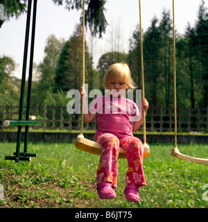 Il Toddler ragazza sul bilanciere in giardino Foto Stock